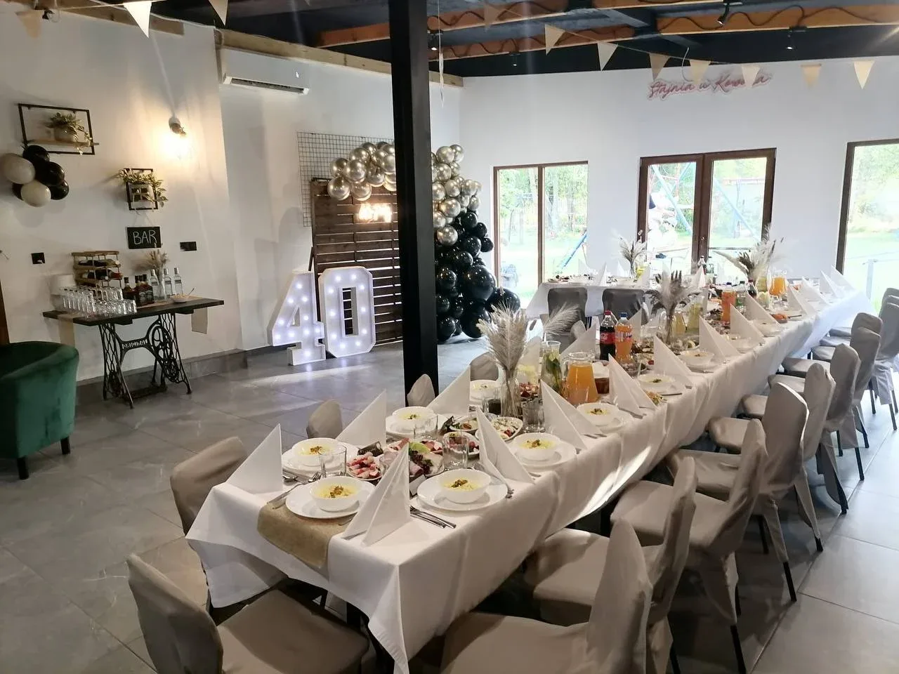 Sala z białymi kwiatami i dekoracją z balonów, przygotowana na uroczystość